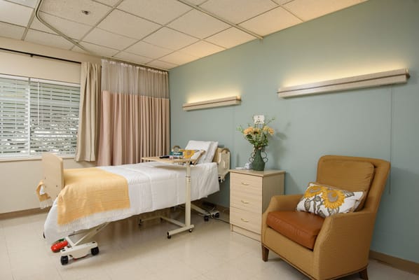 Cozy patient room with bed and chair