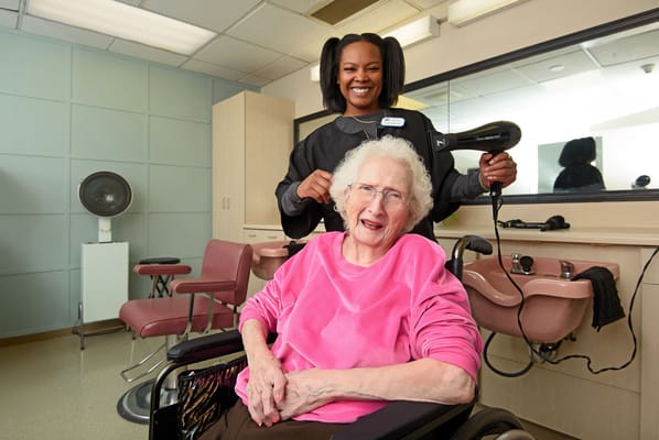 Stylist assisting a resident in a hair salon.