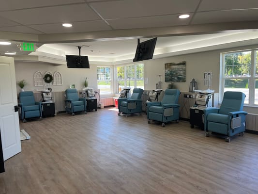 Interior view of a treatment room with chairs and TVs