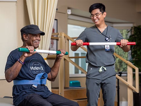 Therapist assisting resident with rehabilitation exercises