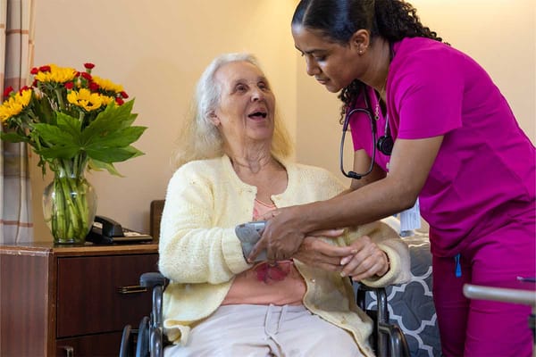 Healthcare worker assisting a resident in a cozy room