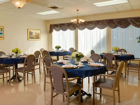 Dining room set up for a meal with flowers on tables