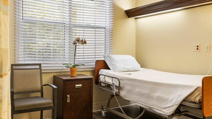 Private resident room with a bed and chair