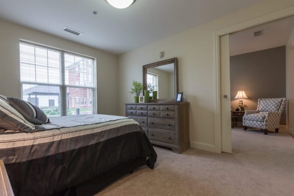 A private resident room with bed and chair