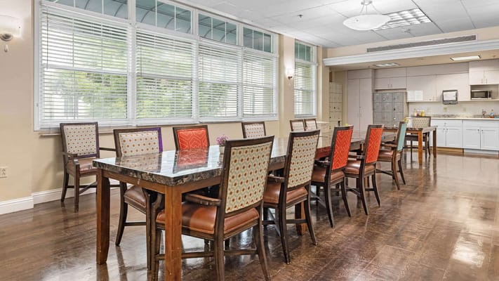 Dining area with colorful chairs and large windows