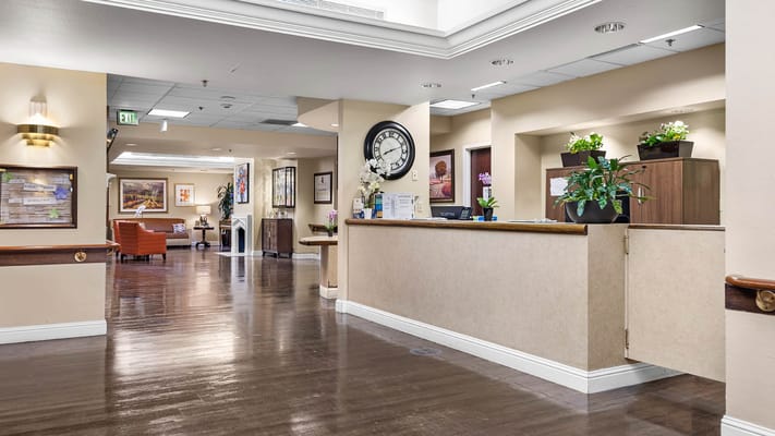 Interior view of a nursing home lobby with seating and plants
