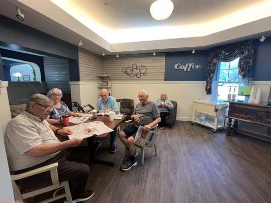 Residents enjoying coffee and newspapers in a common area