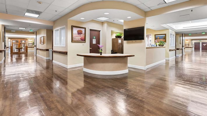 Bright interior hallway of a nursing home with artwork