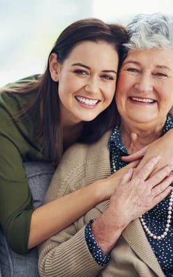 A caregiver and a resident smiling together