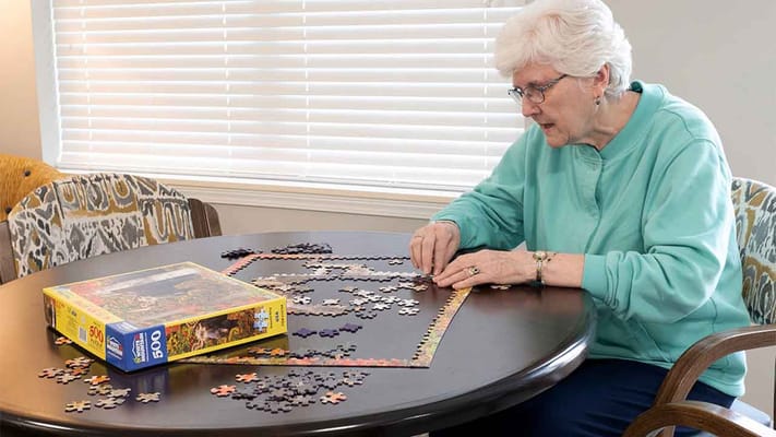 A resident working on a puzzle at a table