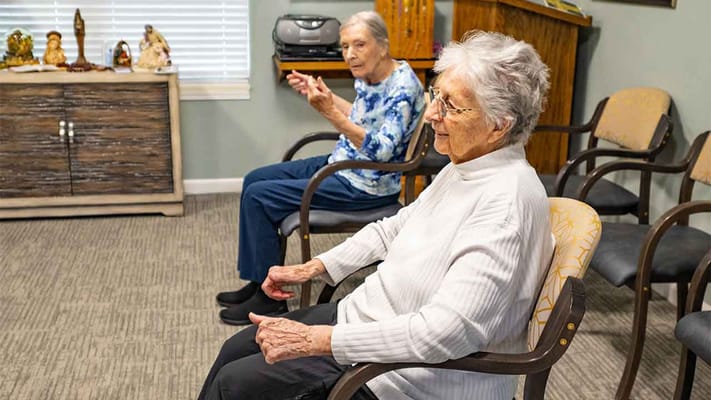 Two senior residents sitting in a common area