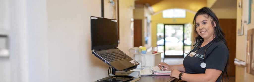Staff member at a reception desk in a care center
