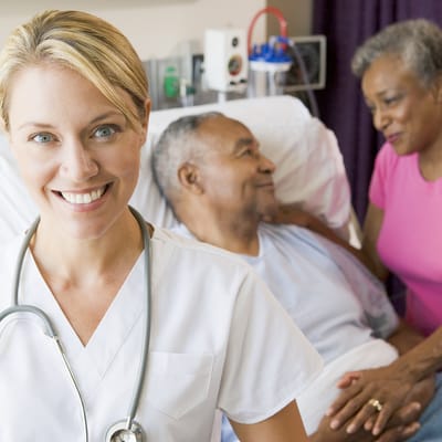 Nurse interacting with senior residents in a hospital room