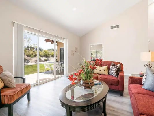 Bright interior common area with seating and a view of the outdoor garden