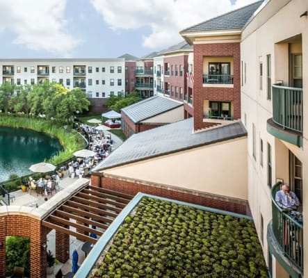 View of outdoor social area with residents by the pond