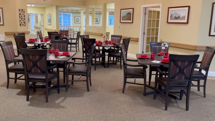 Dining room with neatly set tables and red accents