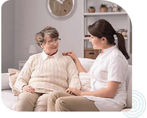 A caregiver interacting with an elderly resident in a cozy setting