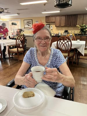 Resident enjoying tea and cookie in the dining room