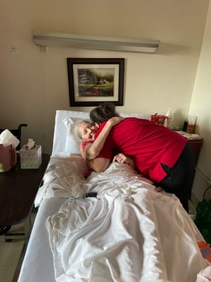 Staff member embracing a resident in a care room