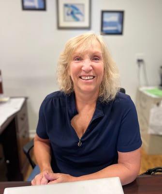 Staff member smiling at their desk in the facility