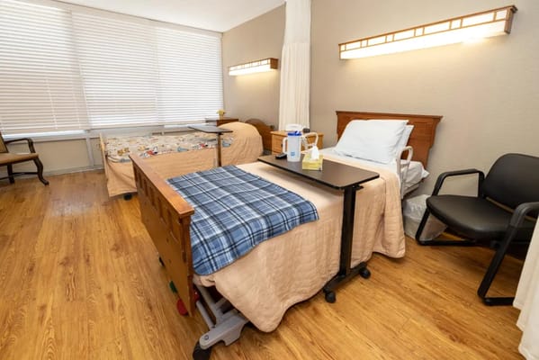 Interior view of a resident's room with beds and furniture