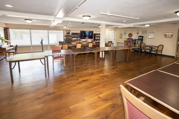 Common area with tables and chairs set up for activities
