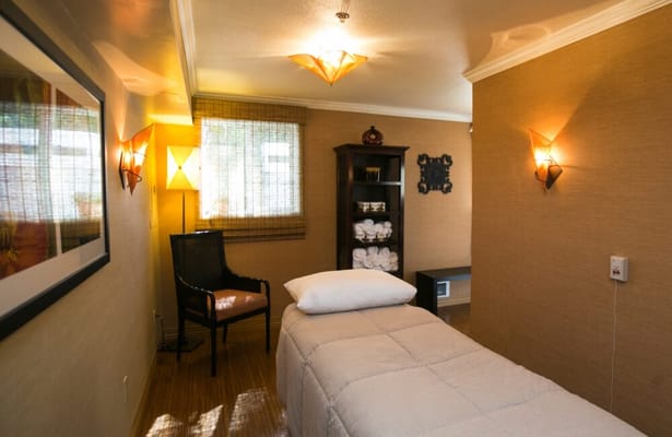 Well-lit spa room with massage table and decorative lighting