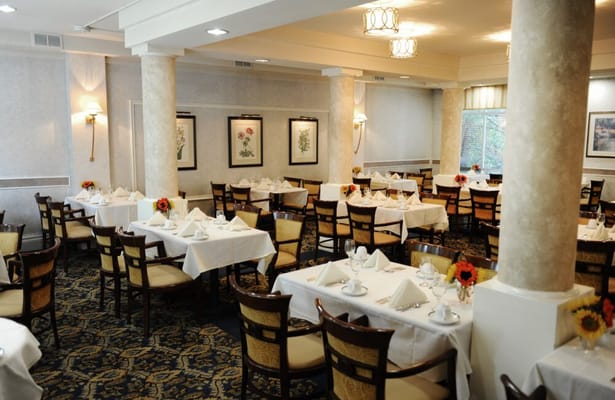 Elegant dining room with neatly arranged tables and flower centerpieces