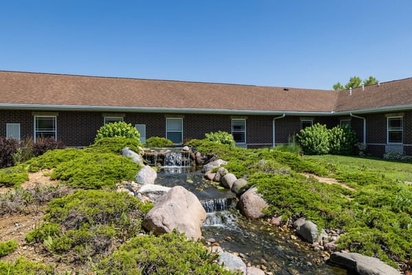 Small waterfall surrounded by greenery and rocks