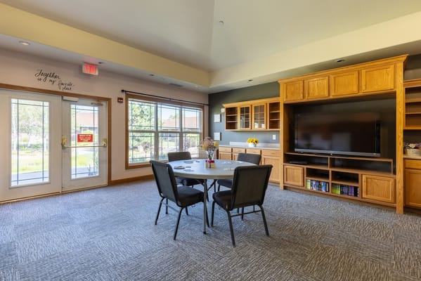 A well-furnished common area with a dining table and chairs