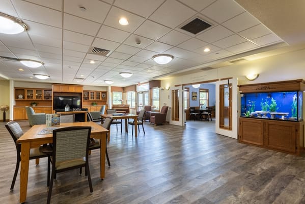 Spacious common area with tables, chairs, and an aquarium