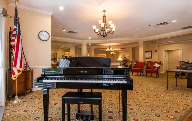 Interior view of a common area with a piano and seating