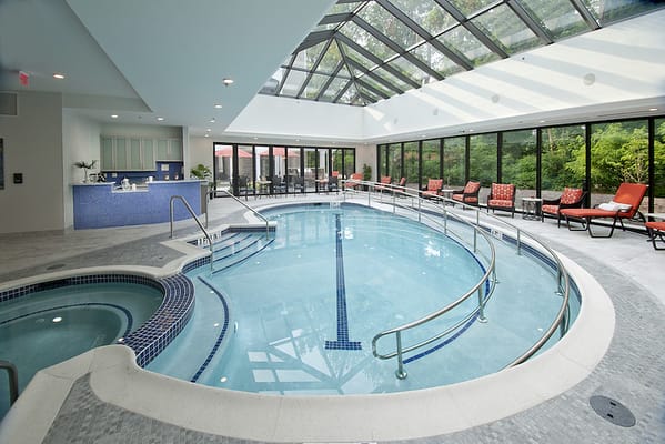Indoor pool area with natural lighting and lounge chairs