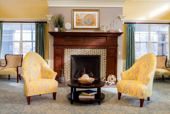 Cozy living room area with yellow chairs and a fireplace
