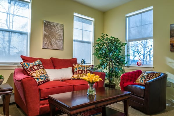 Cozy lounge area with a red couch and natural light