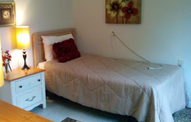 A simple private room with a bed and lamp