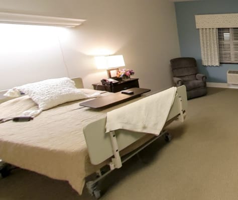 Well-furnished private resident room with a bed and armchair