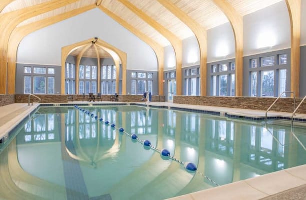 Indoor swimming pool with wooden arch ceiling