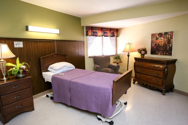 A cozy private resident room with a bed and seating area