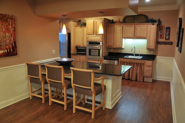 Modern kitchen area with seating and cabinets