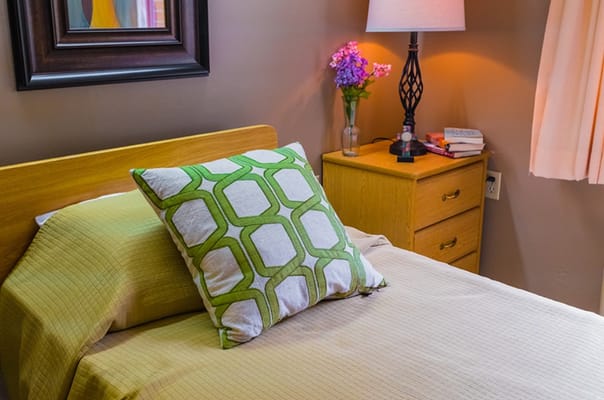 Cozy resident room with bed and lamp