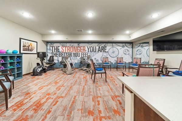 Interior fitness area with exercise equipment and motivational wall