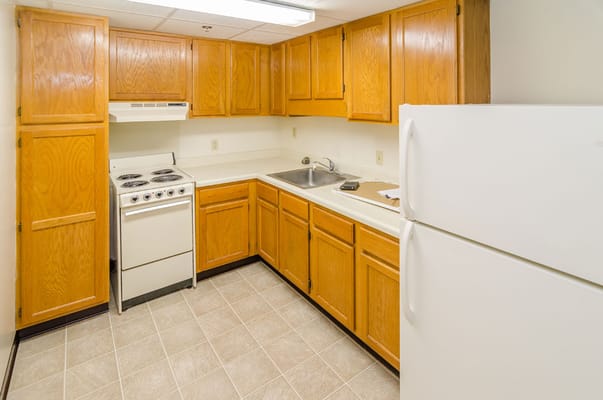 Compact kitchen with wooden cabinets and appliances