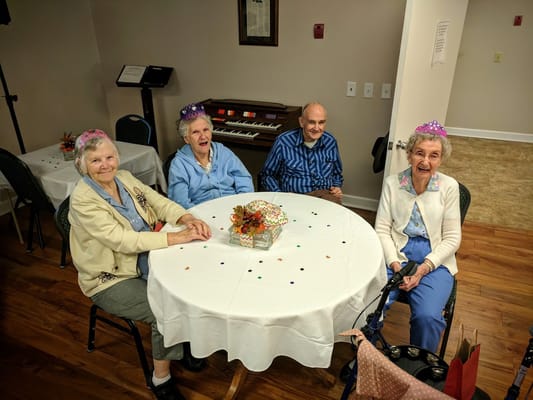Four seniors enjoying a festive gathering at a decorated table