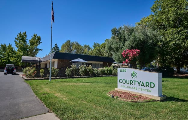 Entrance of Courtyard Healthcare Center with landscaping and sign