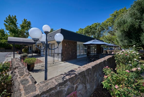 Courtyard Healthcare Center's entrance with outdoor seating and landscaped surroundings