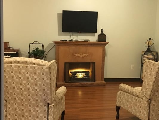 Indoor sitting area with chairs and a decorative fireplace