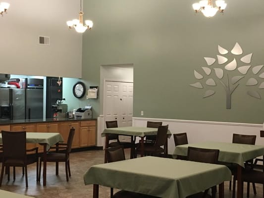 Dining area with tables and kitchen visible