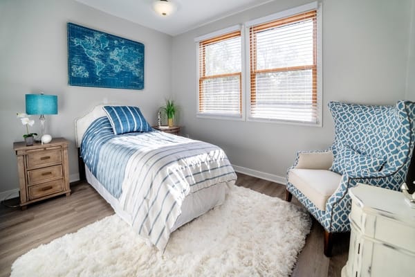 Brightly decorated resident bedroom with windows