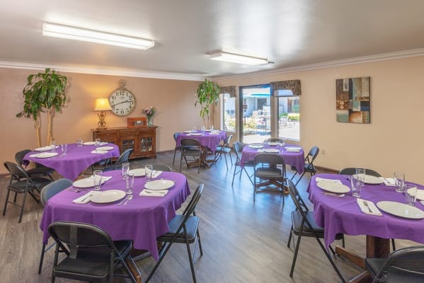 Dining area set with purple tablecloths and utensils